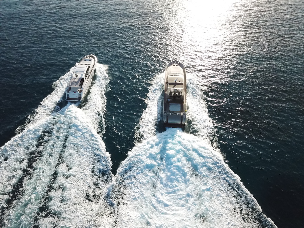 Two yachts cruising together toward the horizon